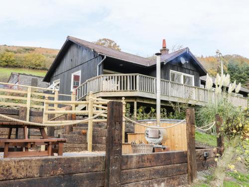 a house with a wooden fence in front of it at Middle Hivron in Bleddfa