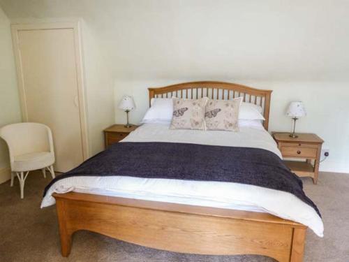 a bedroom with a large wooden bed with two night stands at Coorie Doon in Nairn