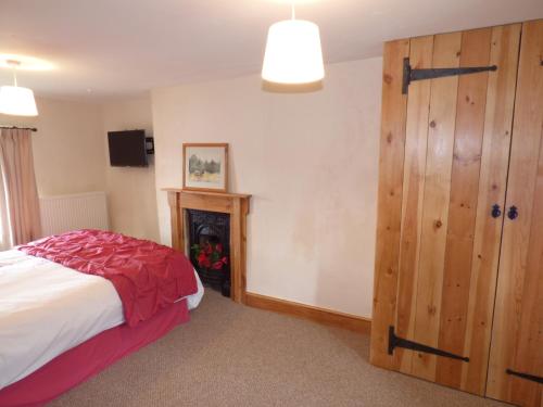 a bedroom with a bed and a wooden closet at Ffynnon Gower in Llangower