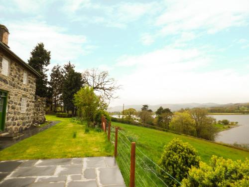 a view of a house with a fence and a lake at Ffynnon Gower in Llangower