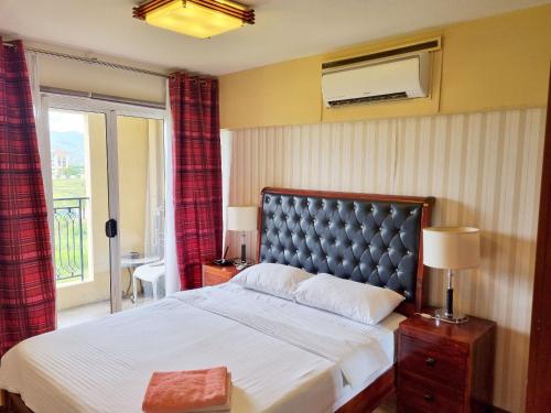 a bedroom with a large bed and a window at Amalfi Oasis Seaside Cebu in Cebu City