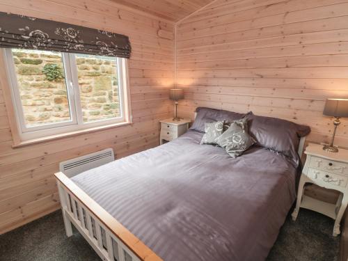 AshoverにあるThorntree Lodgeの木製の部屋にベッド1台が備わるベッドルーム1室があります。