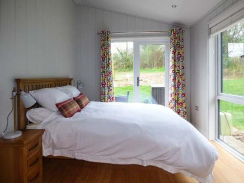 a bedroom with a large white bed and a window at Shepherd Lodge in Cartmel