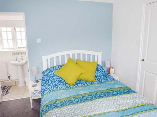a bedroom with a bed with yellow pillows at 9 Swallow Court in Herne