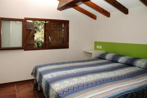 - une chambre avec un lit doté d'une tête de lit verte et d'une fenêtre dans l'établissement Apartment in Pinarellu near famous beach, à Zonza