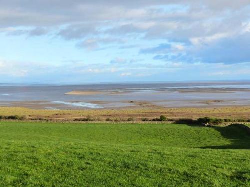 a green field with a view of a body of water at Simmer Dim in Kirkbean