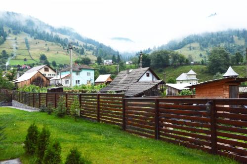 a village with a wooden fence in a field at Cabana Plapumioara in Crucea