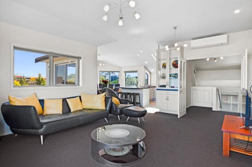 a living room with a couch and a table at Endless Summer - Mount Maunganui Holiday Home in Matapihi