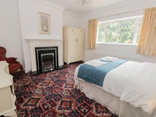 a bedroom with a bed and a fireplace at Granville Lodge in Great Givendale