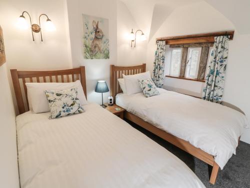 2 camas individuais num quarto com uma janela em Sundial Cottage em Brassington