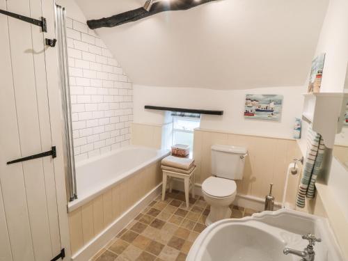 ein Badezimmer mit Badewanne, Toilette und Waschbecken in der Unterkunft Sundial Cottage in Brassington