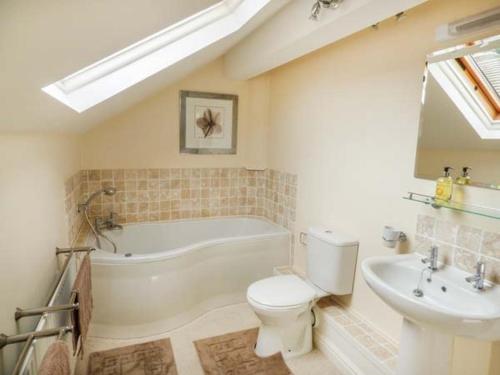 ein Badezimmer mit einer Badewanne, einem WC und einem Waschbecken in der Unterkunft Poacher's Rest in Great Rowsley