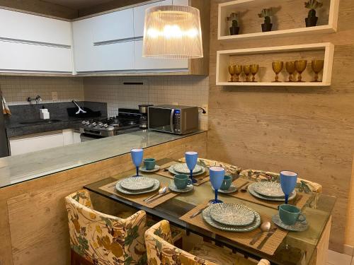 uma cozinha com uma mesa de madeira com pratos em Carneiros Beach Resort - Flat 205-A em Praia dos Carneiros