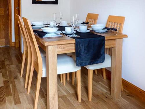 een houten tafel met stoelen en een eetkamer bij 1 The Potteries in Eryholme
