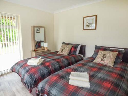 a bedroom with two beds and a mirror at Cwm Gran Meadows in Llanharan