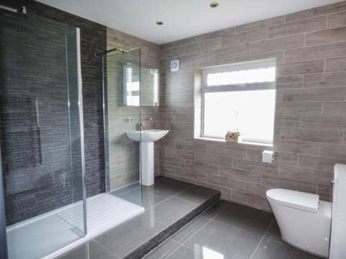 y baño con ducha, aseo y lavamanos. en Cwm Gran Meadows, en Llanharan