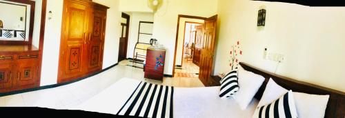 a bedroom with a bed with black and white pillows at Villa 252 Kosgoda in Kosgoda