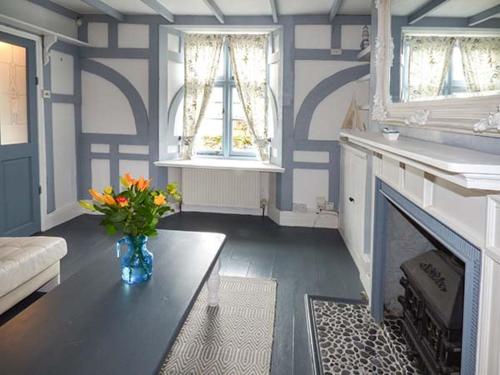 ein Wohnzimmer mit einem Kamin und einer Vase aus Blumen in der Unterkunft Blue Harbour Cottage in Torquay