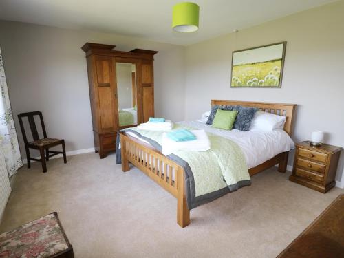 a bedroom with a bed and a chair in it at Pen Y Cae in Llansannan