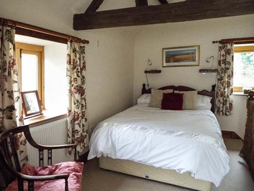 a bedroom with a large bed and a window at The Old Cider House in Southam
