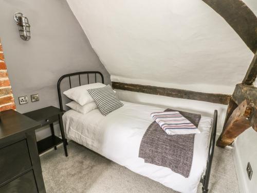 a small bedroom with a bed and a desk at 4 Masons Court in Stratford-upon-Avon