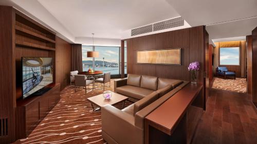 a living room with a couch and a tv at Altira Macau in Macau