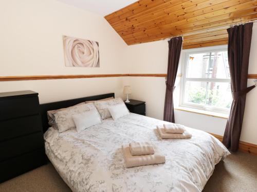 a bedroom with a bed with two towels on it at Cae Tanws Bach in Dolgellau