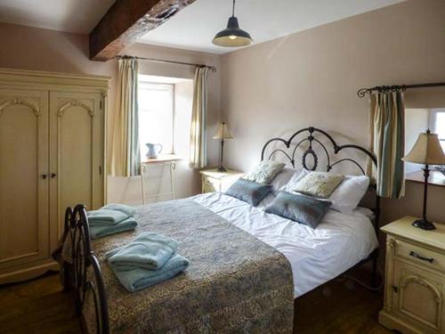 a bedroom with a large white bed with blue pillows at Bran Goesgoch in Holyhead