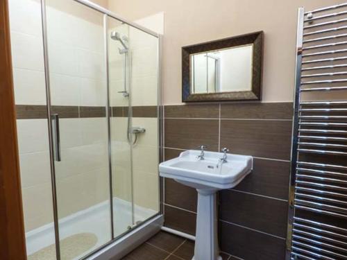a bathroom with a sink and a glass shower at Y Wylan in Holyhead
