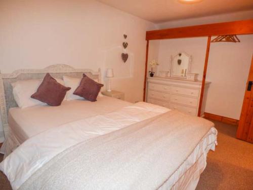 sypialnia z dużym białym łóżkiem i komodą w obiekcie Edendale w mieście Longframlington