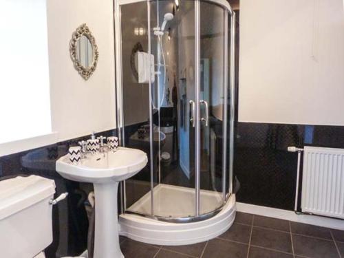 a bathroom with a shower and a sink and a toilet at Coastal Cottage in Inverallochy