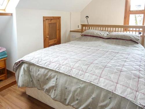 a bedroom with a large bed with a wooden headboard at Lakefield Apartment in Bearnock