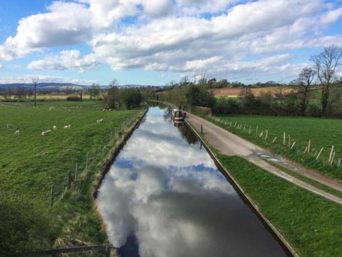a river with a reflection of the sky in the water at Gwdihw in Ifton Heath