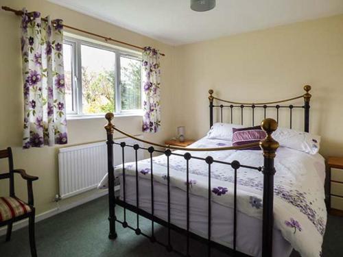 a bedroom with a bed and a window with curtains at Goldings in Wells