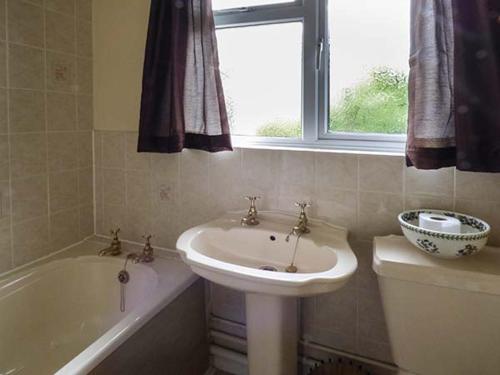 a bathroom with a sink and a bath tub at Goldings in Wells