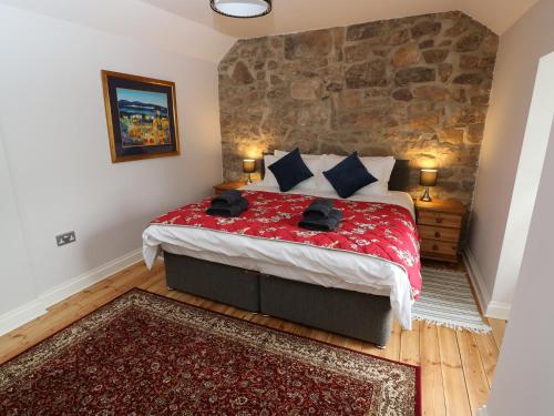 a bedroom with a large bed with a stone wall at Riber View in Matlock