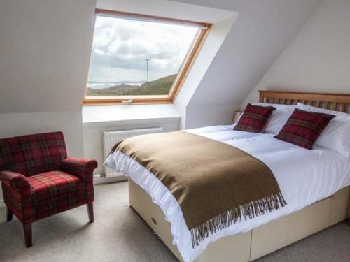 a bedroom with a bed and a window and a chair at Skipaflotta in Rhiconich