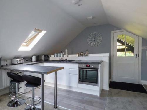 a kitchen with a counter and a clock on the wall at Studio at Little Trees Farm in Kingsbourne Green