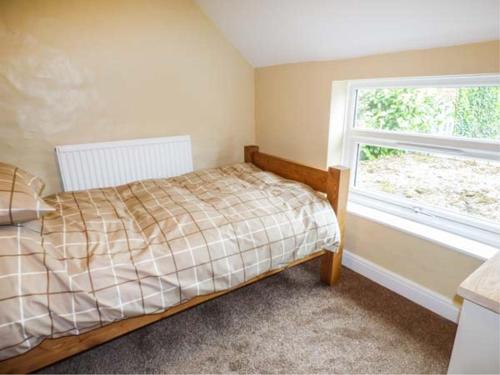 Fran's Cottage في Millington: غرفة نوم بسرير ونافذة