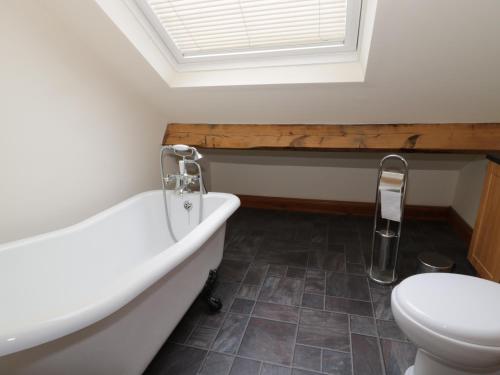 a bathroom with a bath tub and a toilet at Dumbuie in Haltwhistle