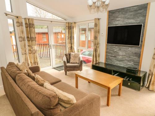 a living room with a couch and a flat screen tv at Coniston Number 9 in Troutbeck Bridge
