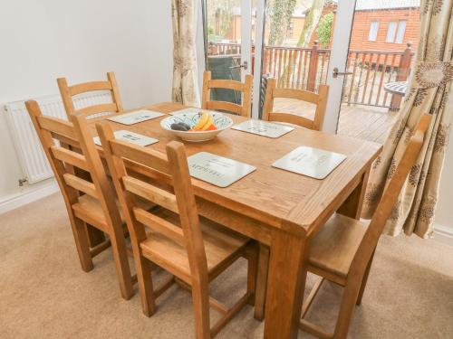 a wooden table with chairs and a bowl of fruit on it at Coniston Number 9 in Troutbeck Bridge