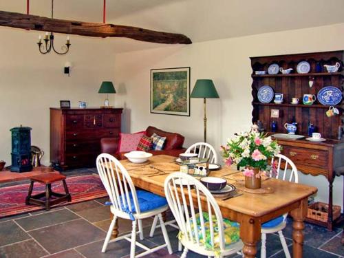 a living room with a wooden table and chairs at Ginny's Barn in Askham