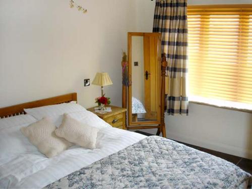 a bedroom with a large bed and a window at Ginny's Barn in Askham
