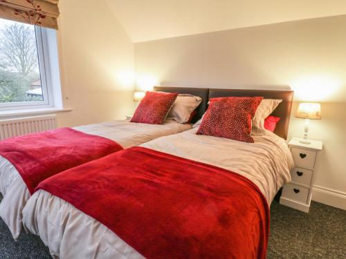 dwa łóżka siedzące obok siebie w sypialni w obiekcie Sunnyside Garden Cottage w mieście Husthwaite