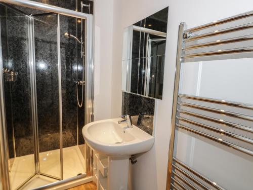 une salle de bain avec lavabo et douche dans l'établissement Sunnyside Garden Cottage, à Husthwaite