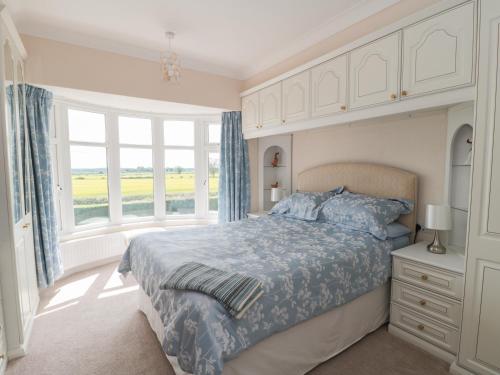 a bedroom with a bed and a large window at 75 Mansfield Road in Ault Hucknall