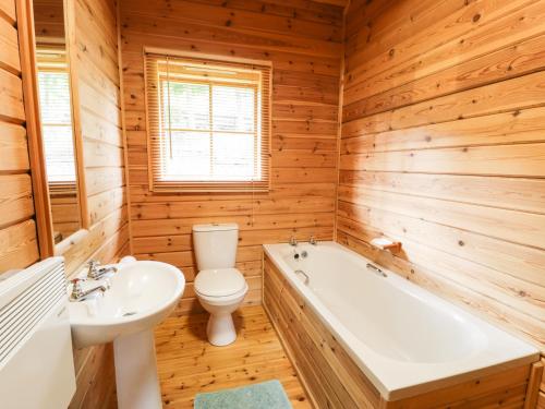 uma casa de banho com um WC, uma banheira e um lavatório. em Sunset Lodge 6 em Llanbedr