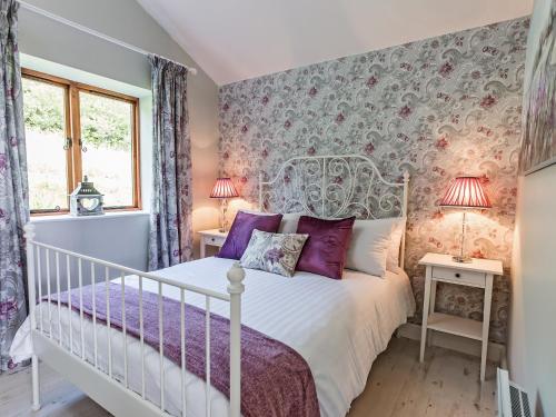 a bedroom with a white bed with purple pillows at Stoney-Brook Lodge in Farden