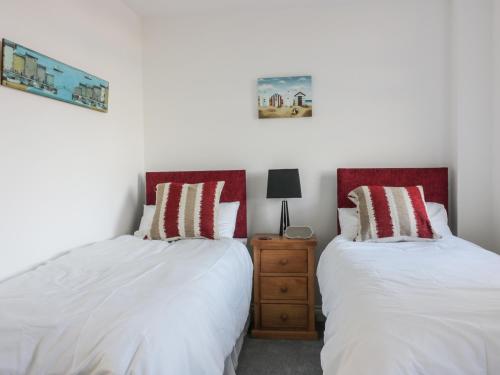 two beds sitting next to each other in a bedroom at Fistral Breeze in Newquay